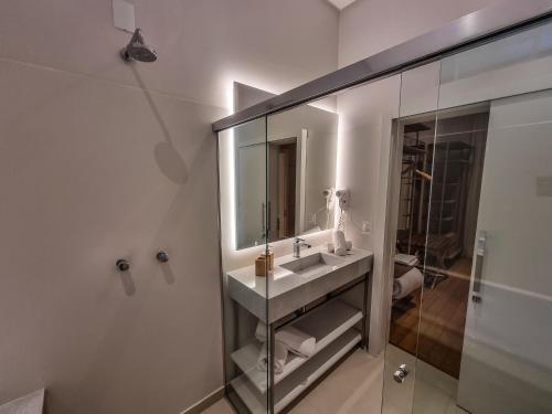 a bathroom with a sink and a mirror at Mosteiro Hotel de Charme próximo ao Vale dos Vinhedos in Garibaldi
