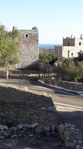 a road next to a building with a stone wall at Πέτρινο σπίτι-Stone house in Koíta