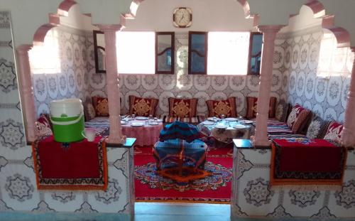 a dining room with a table and chairs at Dar Brahim tizgui nbarda in Ouarzazate