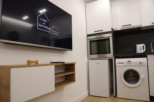 a kitchen with a washing machine and a tv at Come&Recome Tirana Apartments in Tirana