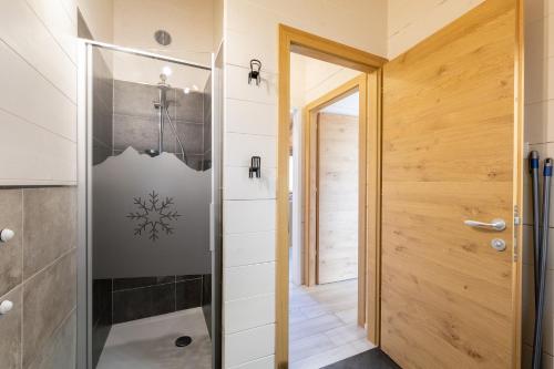 a bathroom with a walk in shower next to a door at Ivan House in Livigno