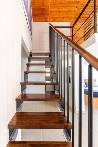a staircase with wood and metal railings in a house at La Caletta di Afrodite in Calabernardo