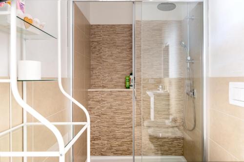 a shower with a glass door in a bathroom at La Caletta di Afrodite in Calabernardo
