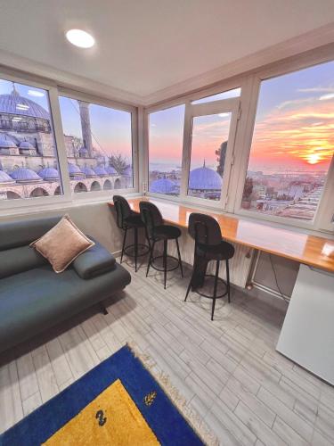 a living room with a table and chairs and windows at SULTANAHMET ROYAL APART in Istanbul