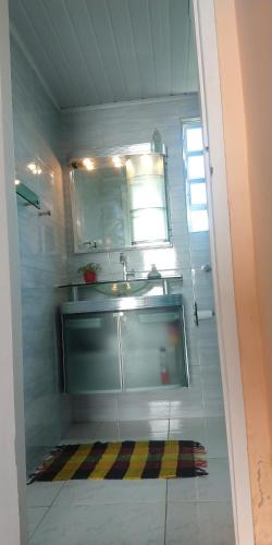 a small bathroom with a sink and a mirror at Casa do Mirante in Petrópolis