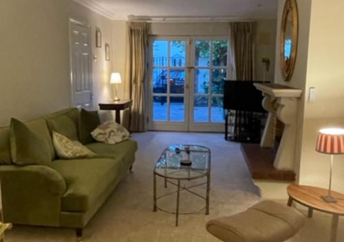 a living room with a green couch and a tv at Fashionable Chic Townhouse in D4 in Dublin