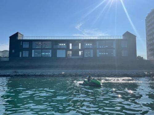 a person in a boat in the water in front of a building at Haon Terrace Suite Villa Ango - Vacation STAY 30531v in Sumoto