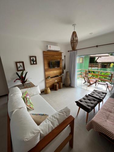 Una sala de estar con un sofá blanco y una mesa. en Trancoso43 - Lindo apartamento 1 suíte , sala com varanda, en Trancoso
