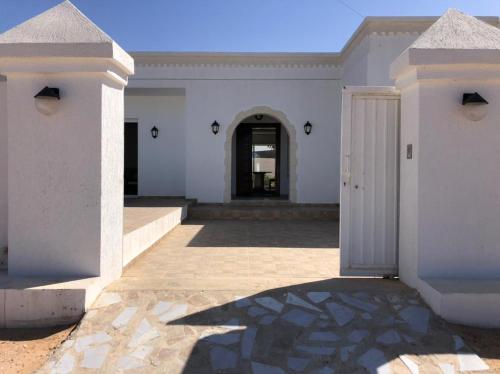 a white house with a door and a courtyard at Villa Lucia in Djerba