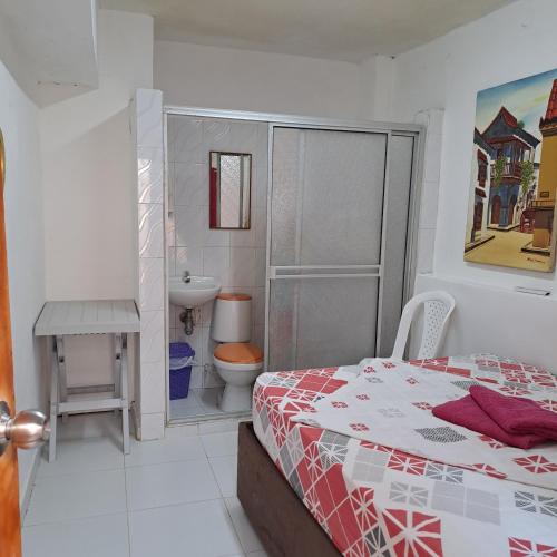 a bedroom with a bed and a toilet and a sink at Hostal Casa Lara in Cartagena de Indias