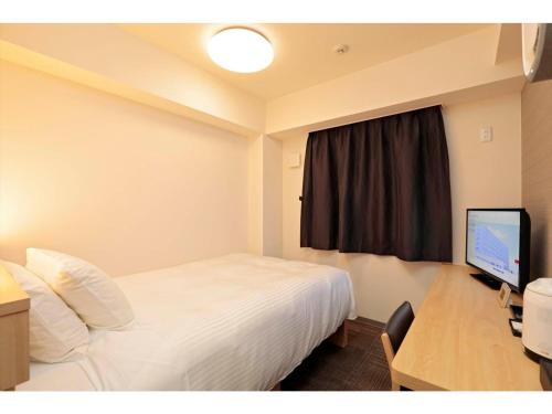 a hotel room with a bed and a desk and a television at A&Bee HOTEL - Vacation STAY 35415v in Oita