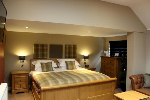 a bedroom with a large bed with two pillows at The Blue Bell at Arkendale in Knaresborough