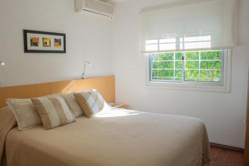 1 dormitorio con 1 cama grande y ventana en Hotel Ajax en Punta del Este