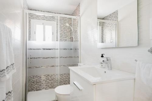 a white bathroom with a toilet and a sink at Habitaciónes bonitas y cómodas in Hospitalet de Llobregat