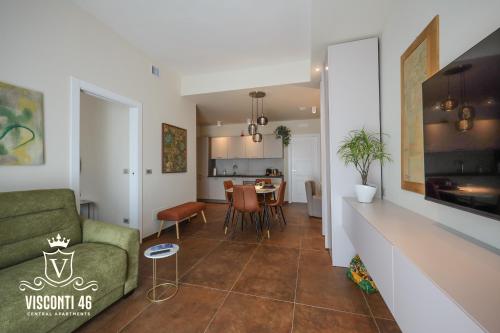 ein Wohnzimmer und eine Küche mit einem Sofa und einem Tisch in der Unterkunft VISCONTI 46 Central Apartments in Bari