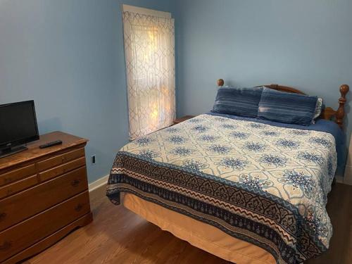a bedroom with a bed and a dresser with a television at Bennington stay in Bennington