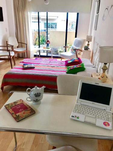 a laptop computer sitting on a table in a living room at Studio Plaza con sillón cama in Buenos Aires