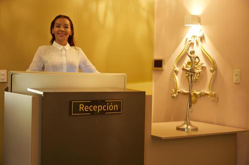 Uma mulher atrás de um pódio numa sala com um troféu. em DUO BOUTIQUE HOTEL em Medellín