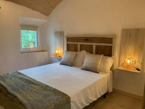 1 dormitorio con 1 cama blanca grande y 2 lámparas en Can Joan Empordà en Ordis