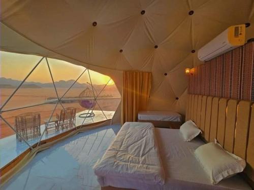 a bedroom with a bed and a view of the ocean at Youssef camp Wadi Rum in Wadi Rum