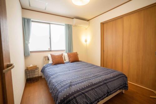 um pequeno quarto com uma cama e uma janela em White Terrace D - Vacation STAY 44940v em Nakadomari