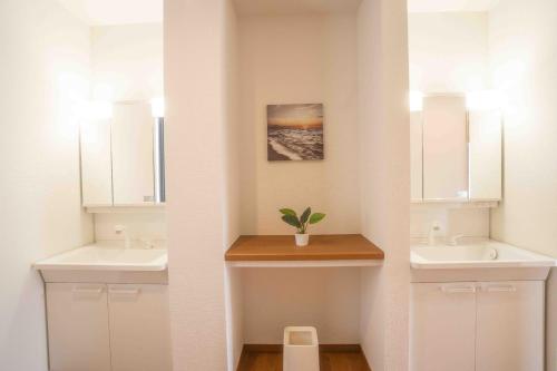 uma casa de banho com dois lavatórios e dois espelhos em White Terrace D - Vacation STAY 44940v em Nakadomari