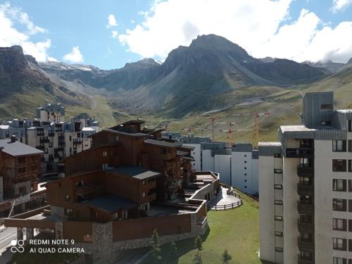 une ville avec des bâtiments et des montagnes en arrière-plan dans l'établissement Studio mezzanine 32m² Tignes, balcon, wifi, lave-linge, séjour lit convertible - FR-1-449-184, à Tignes