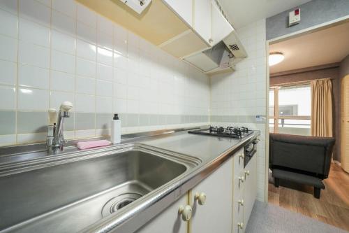 una cucina con lavello in acciaio inossidabile e piano cottura di Residence Hotel KABUTO - Vacation STAY 46143v a Sapporo