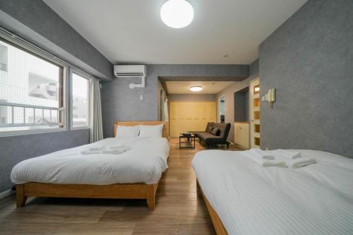 una camera d'albergo con due letti e una sedia di Residence Hotel KABUTO - Vacation STAY 46143v a Sapporo