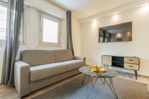 a living room with a couch and a tv at Nice apartment 4P- Levallois Anatole France in Levallois-Perret