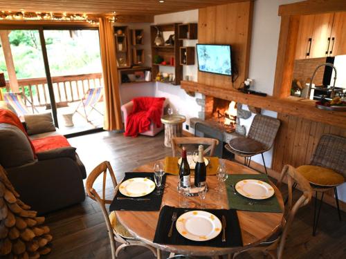 un salon avec une table et des chaises et une cheminée dans l'établissement Appartement 2 chambres proche pistes avec balcon et parking - FR-1-459-181, à La Clusaz