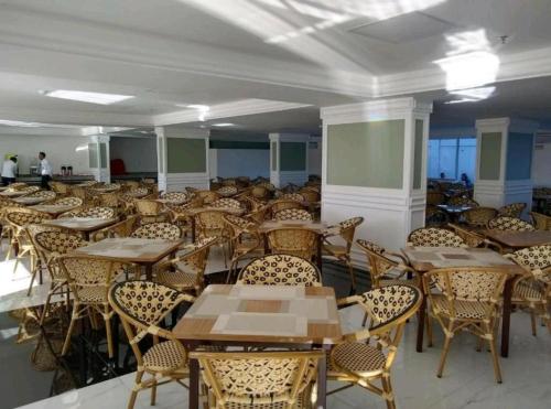 uma sala cheia de mesas e cadeiras em Piazza Diroma - Com acesso Acqua park CN-GO em Caldas Novas