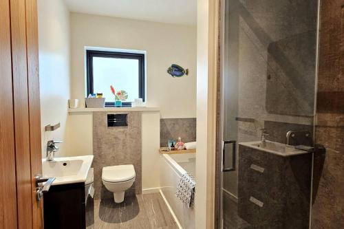 baño con lavabo y aseo y ventana en Luxury 3-Bed House in the Scottish Highlands en Inverness