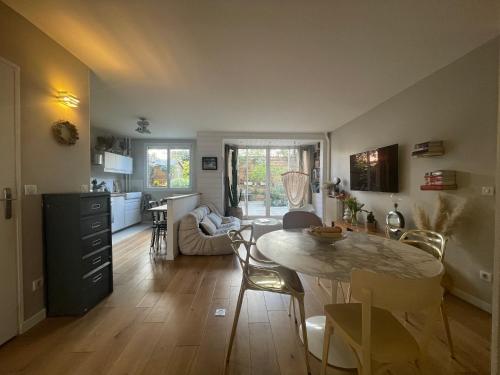 une cuisine et un salon avec une table et des chaises dans l'établissement Appartement familial avec grande terrasse, à Paris