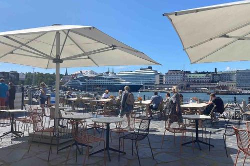 um grupo de mesas e cadeiras com um navio de cruzeiro em Central lux location, self check-in, ensuite with full kitchen em Helsínquia