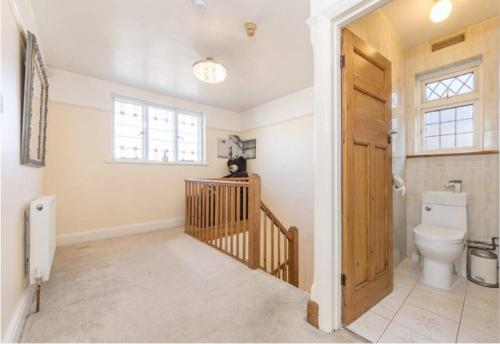 a bathroom with a toilet and a wooden door at Rose Garden House in Luton