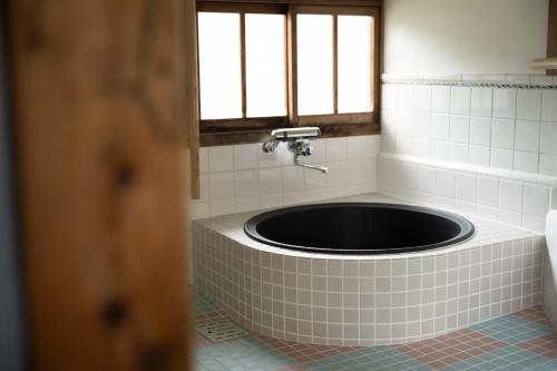 Setouchi base - Vacation STAY 47136v في Mitoyo: حمام مع حوض استحمام مع نافذة