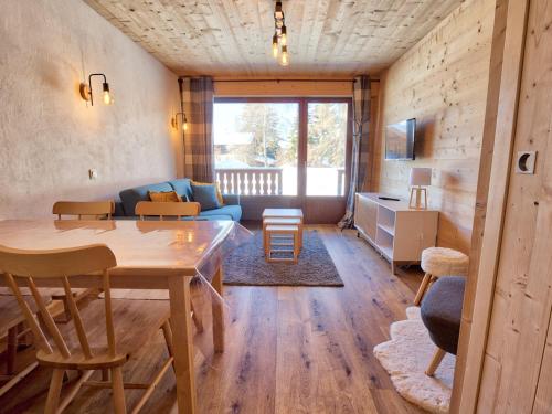 un salon avec une table et un canapé dans l'établissement Studio rénové, proche pistes, parking, confort - FR-1-505-157, à Notre-Dame-de-Bellecombe