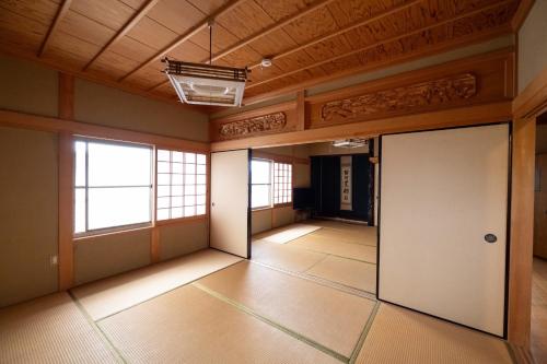 an empty room with a door and a wooden ceiling at Setouchi base - Vacation STAY 47136v in Mitoyo