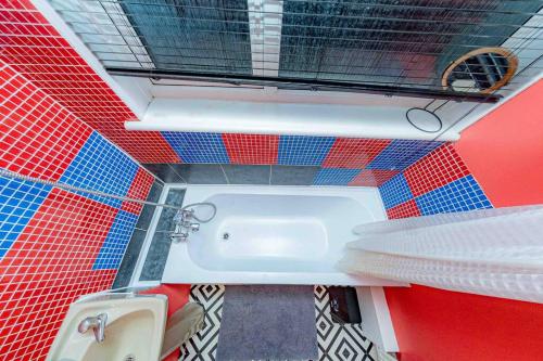 a bathroom with red and blue tiles and a tub at Unique home w/garden hot tub, sauna & cinema room in London