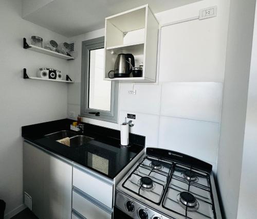 a small kitchen with a stove and a sink at Exclusivo Monoambiente zona Plaza Paso By Lofter in La Plata