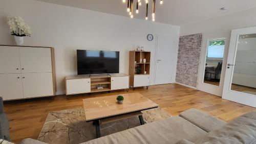 a living room with a couch and a flat screen tv at Quiet House - 10 min away from Cologne in Bergisch Gladbach