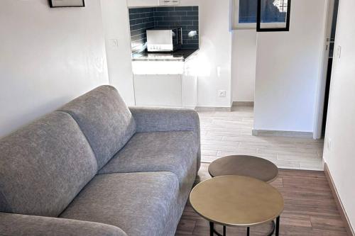 un salon avec un canapé et une table dans l'établissement Cosy home proche de Roissy CDG PARIS, Parc Astérix I Aéroville I Parc des Expo I Villepinte, à Louvres