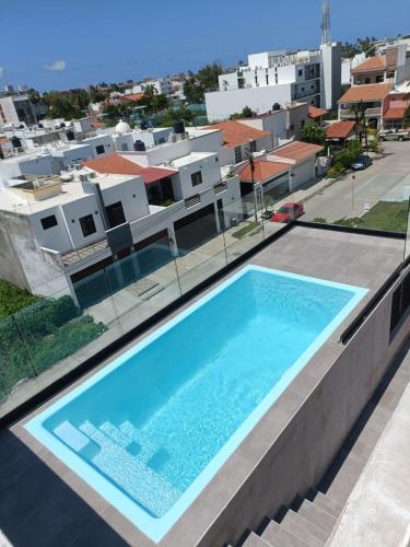 a swimming pool on the roof of a house at Excelente Depa en Sabalo Country in Mazatlán