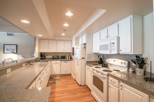 a kitchen with white cabinets and white appliances at 5732 - Beach Music in Nags Head