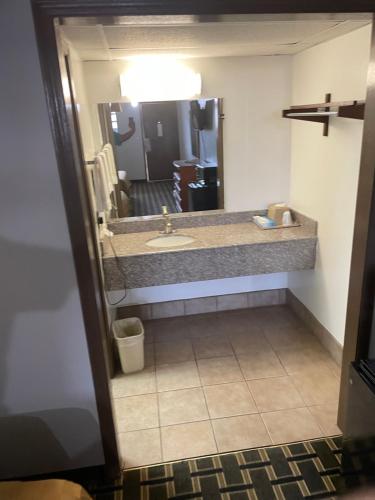 ein Bad mit einem Waschbecken und einem Spiegel in der Unterkunft Bedford Inn in Elk City