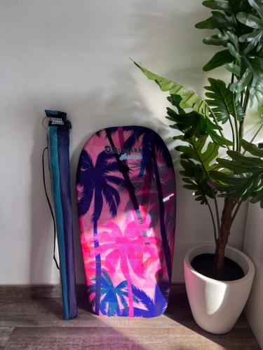 a surfboard sitting on a table next to a potted plant at Apartamento céntrico el Médano in El Médano