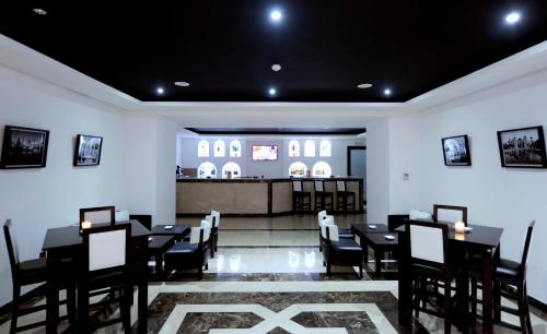 a restaurant with black tables and chairs and a counter at Blue Sea Le Printemps in Marrakech