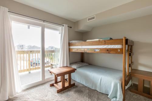 Schlafzimmer mit Etagenbett und Balkon in der Unterkunft 5739 - The Yachtsman - 101 by Resort Realty in Nags Head