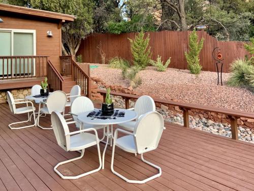 a patio with white chairs and tables on a deck at ULTIMATE Mountain Escape with Pool & Hot Tub & Firepit in Sedona